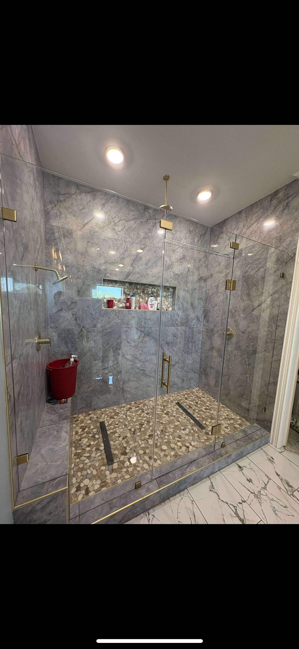 Grey marble walk-in shower with gold hardware by Lorett's Remodeling and Construction in Tulsa, OK